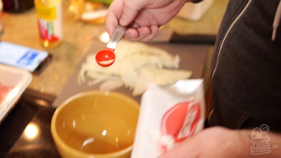 Dashi power is spooned into bowl from package with measuring spoon