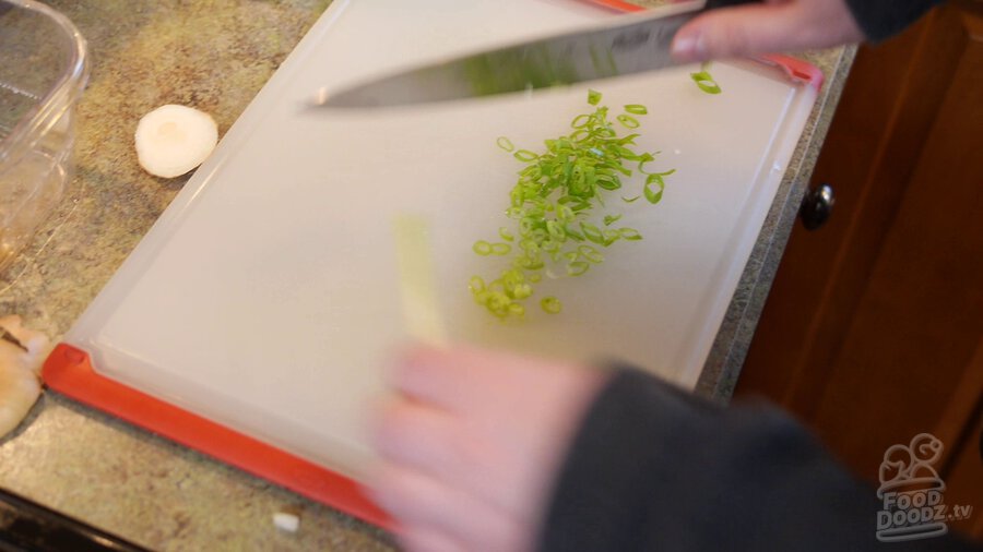 Green onion is sliced on cutting board