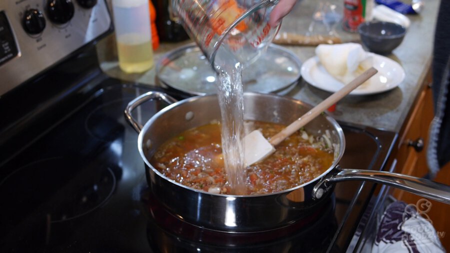 Water is poured into pan from measuring cup