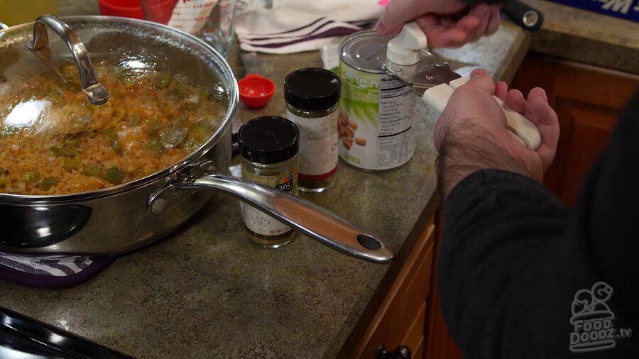 Using can opener to open can of pinto beans