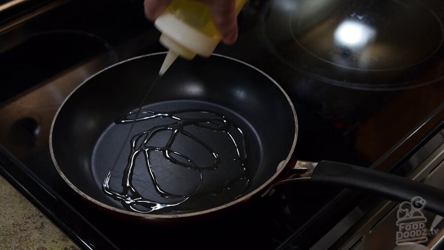 Using squirt bottle to add vegetable oil to non-stick skillet, coating bottom