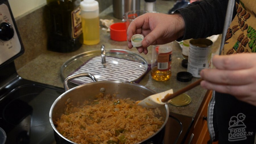 Vinegar is carefully added using the bottle cap to finished Mexican rice. It looks delicious!