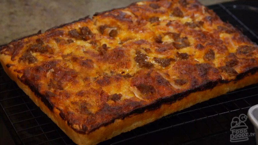 Completed epic pan pizza sits on backing rack to cool after being removed from sheet pan. It looks so tasty!