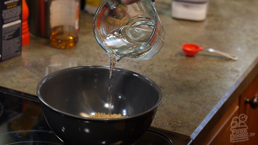 Pouring hot water over bowl of textured vegetable protein (TVP) to rehydrate