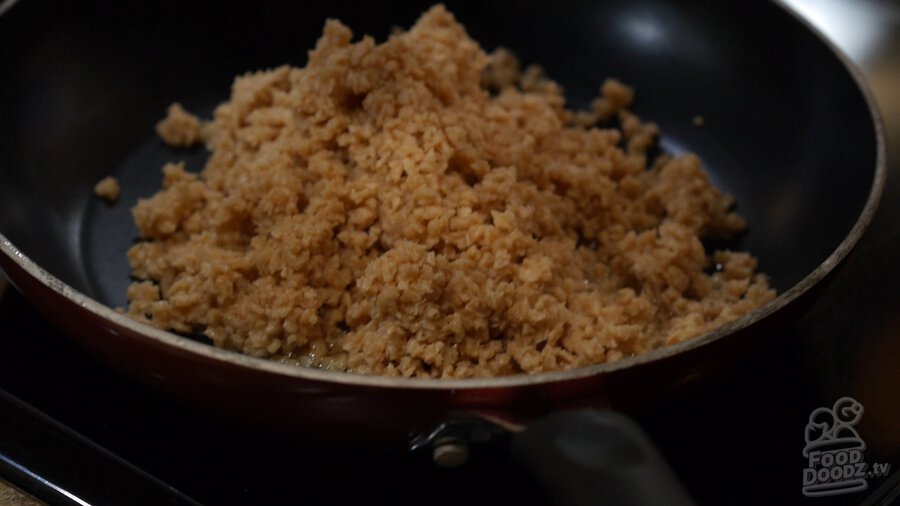 Adding textured vegetable protein (TVP) to oiled skillet/pan over medium heat