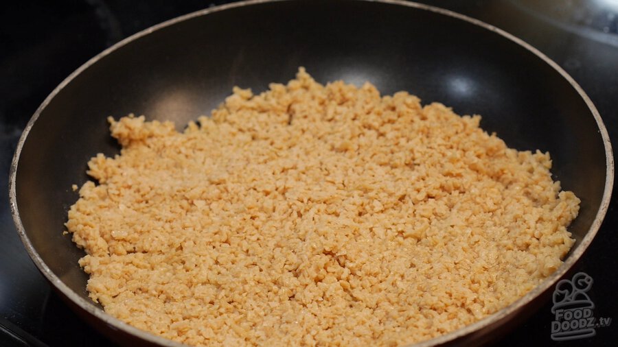 Textured vegetable protein (TVP) flattened in skillet/pan to help brown faster