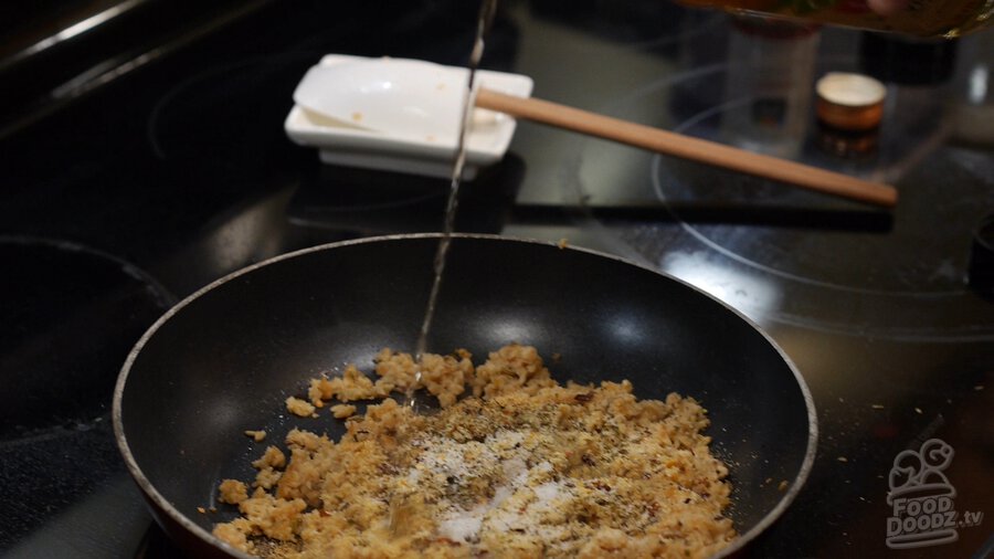 Pouring vinegar into skillet of textured vegetable protein (TVP) sauteing with seasonings
