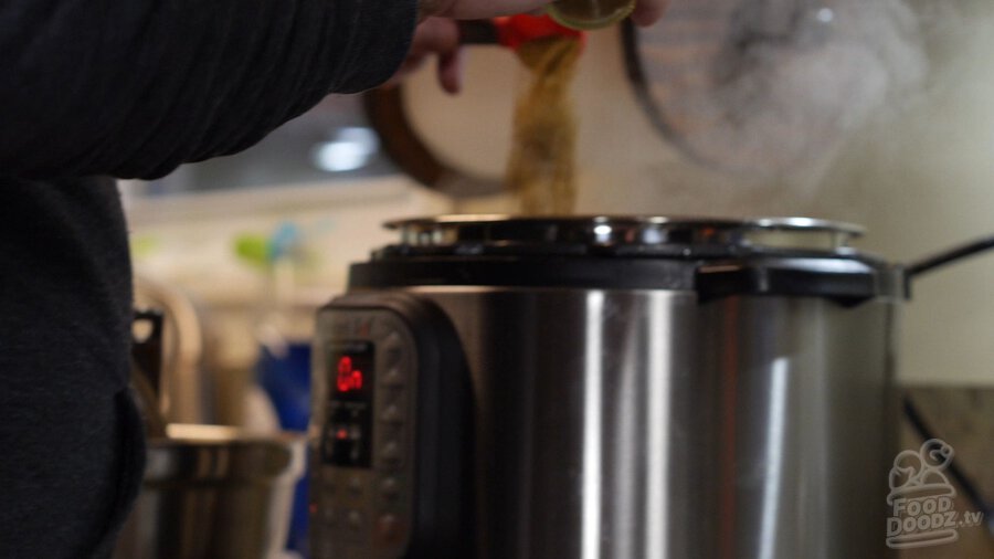 Adding cinnamon, cumin, and oregano to the pan of instant pot