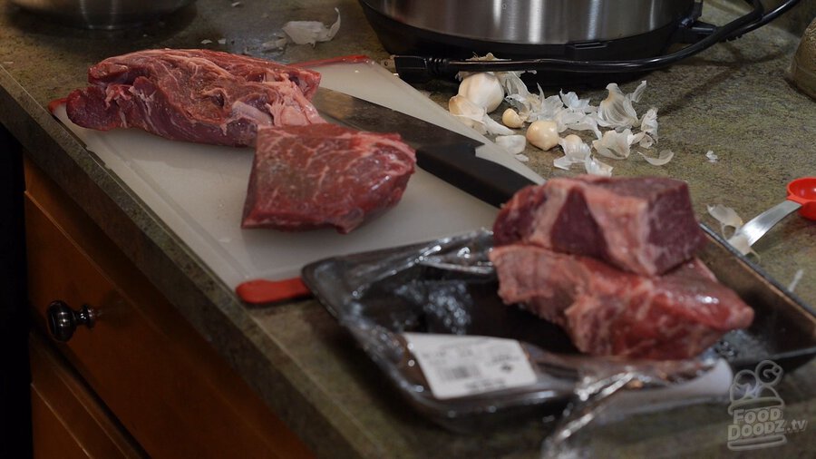 Removing chuck roast beef from package and slicing into large pieces