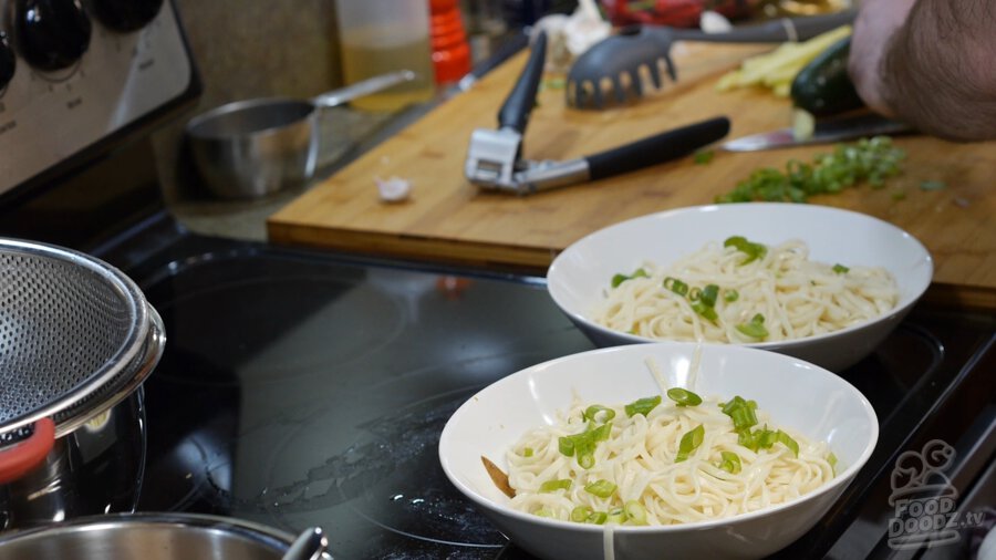 2 bowls with sesame paste, soy sauce, sugar, chinkiang vinegar, noodles, and green onions