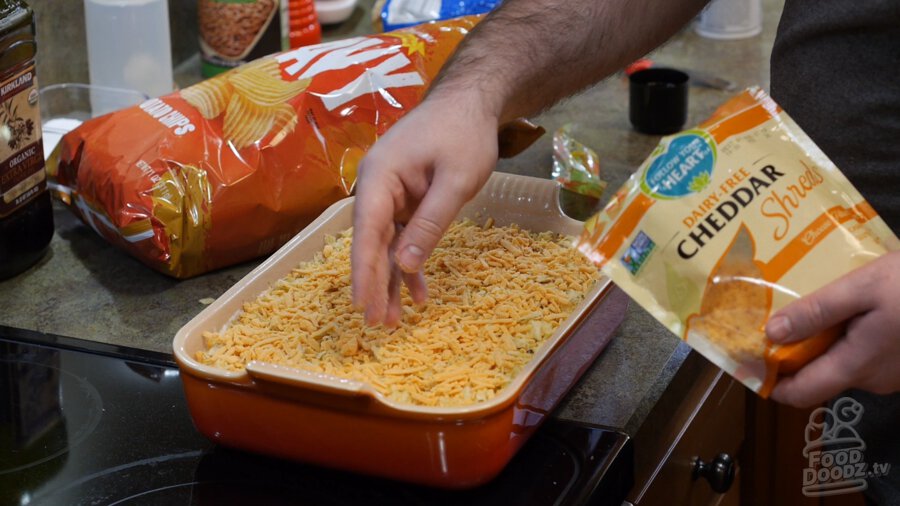 Vegan cheddar cheese evenly sprinkled over top of potato chips