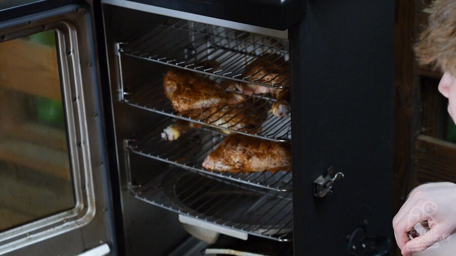 Chicken Quarters racks being slid into the smoker