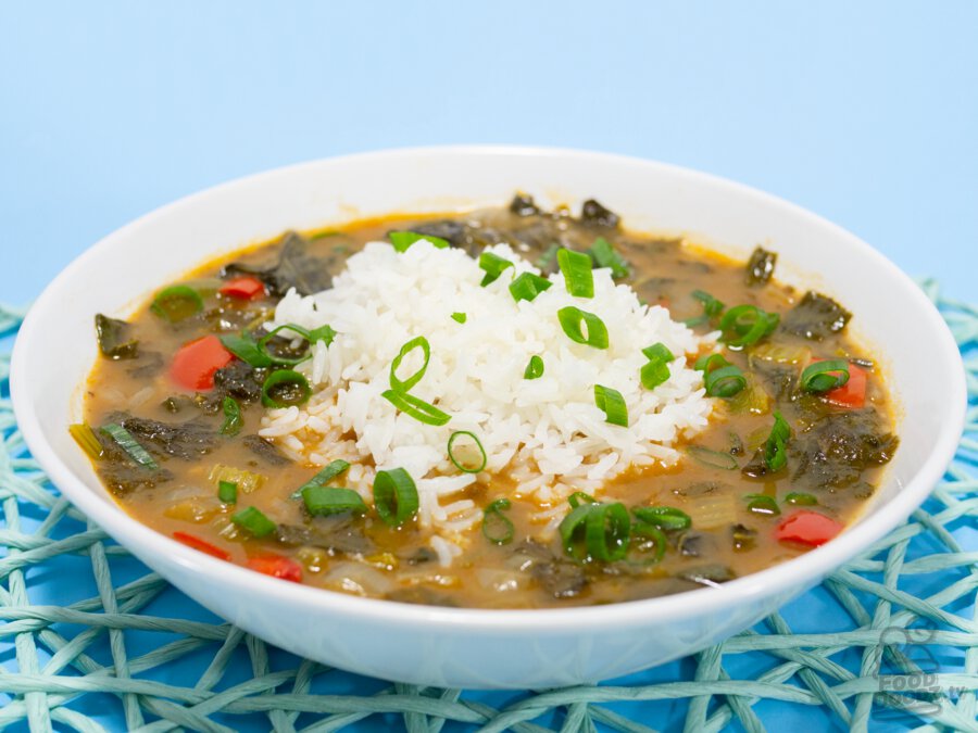 a delicious plate of green gumbo with some white rice and green onions on top