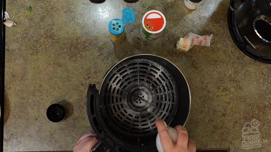 Air fryer tray sprayed with oil