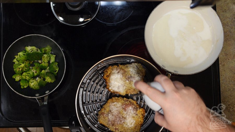 Flipped over steaks being sprayed with more oil