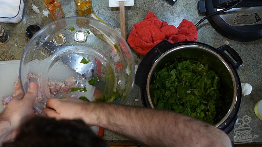 Spinach being added on top of the onions, garlic, ginger, and spices
