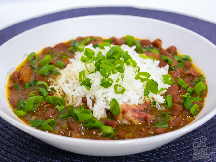 A bountiful bowl of cajun red beans and rice topped with green onions and parsley