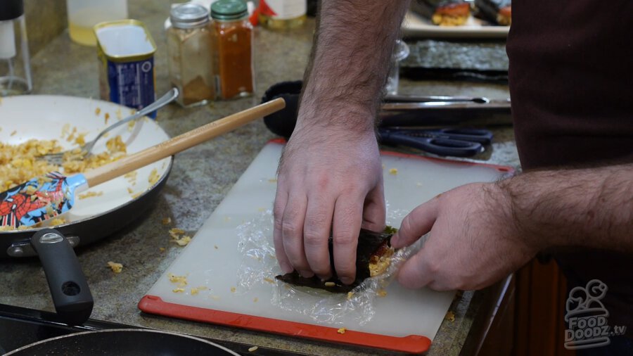 Nori being wrapped around spam and rice