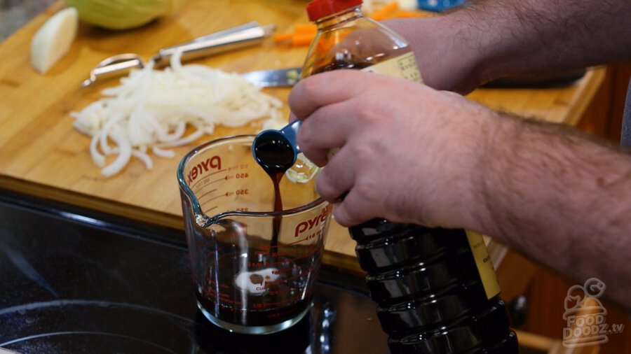 adding soy sauce to bowl