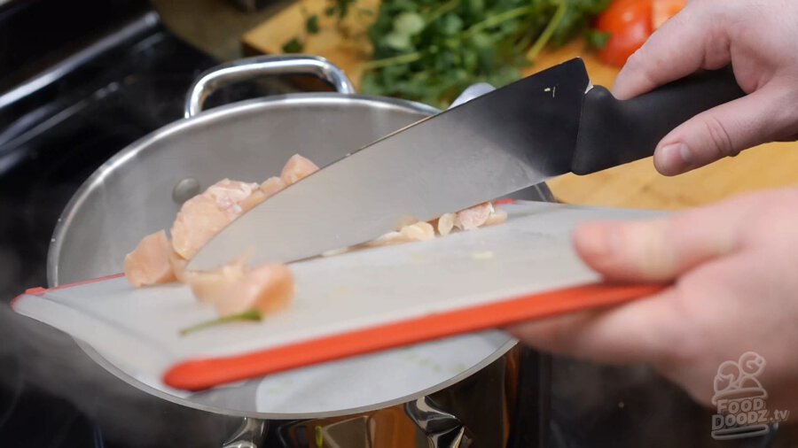 Chicken being added to pot