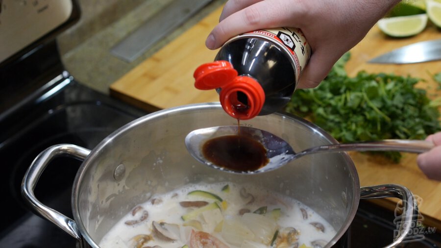 Soy sauce being measured out and about to be added to the pot