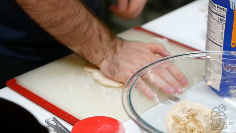 Flattening the dough on my cutting board to about 1/4 to 1/2 inch thick