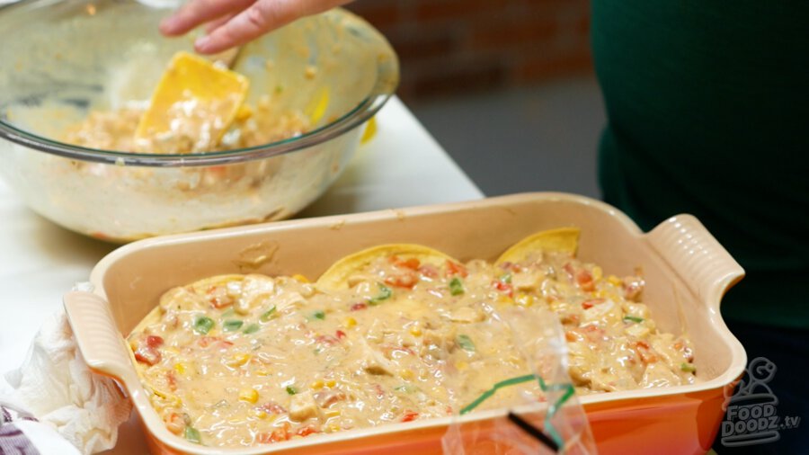 Spreading more chicken sauce over tortillas