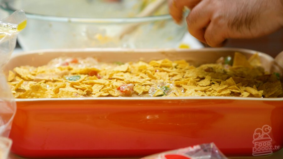 Crushing up tortilla chips to cover the top