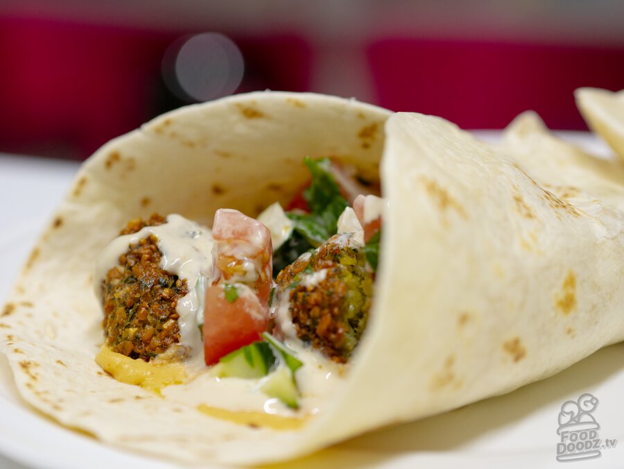 A rolled up finished falafel wrap