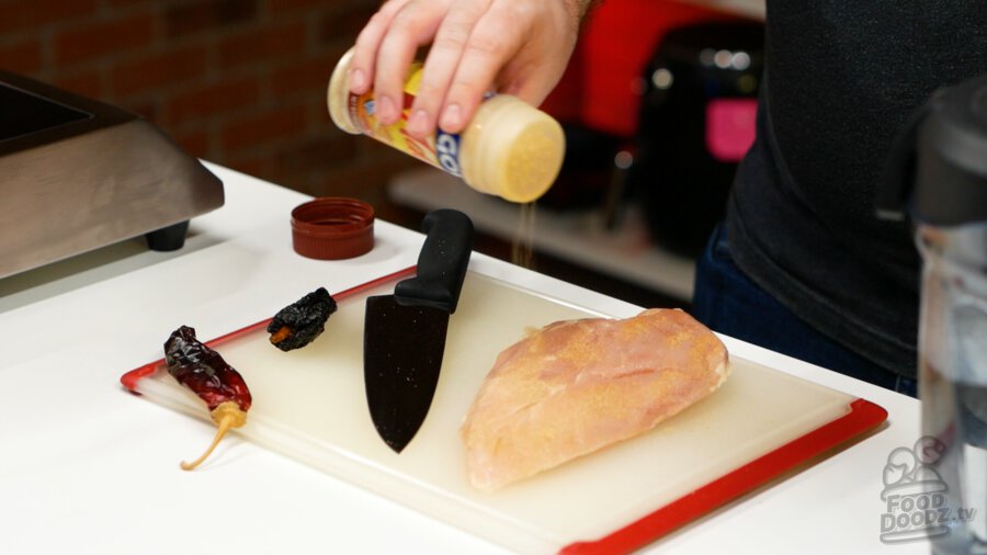 Seasoning chicken breast with adobo seasoning