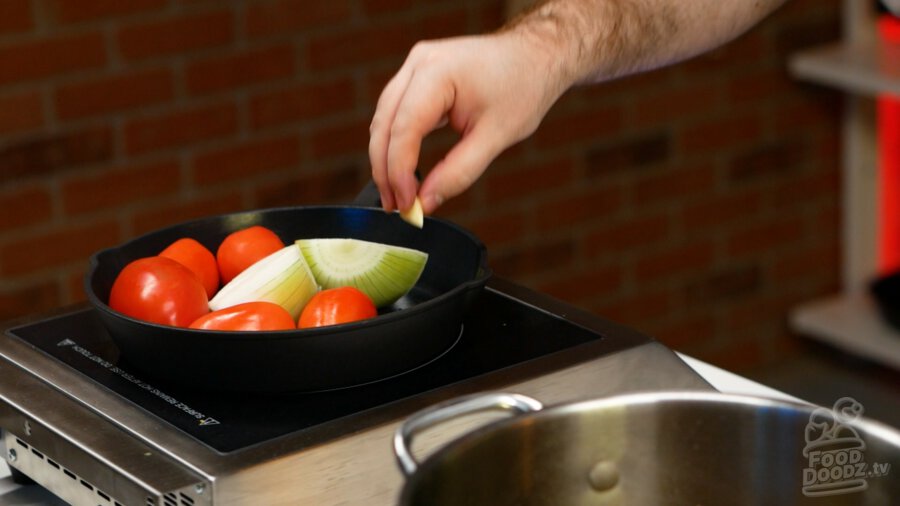 Tomatoes, onion, and garlic added to hot pan