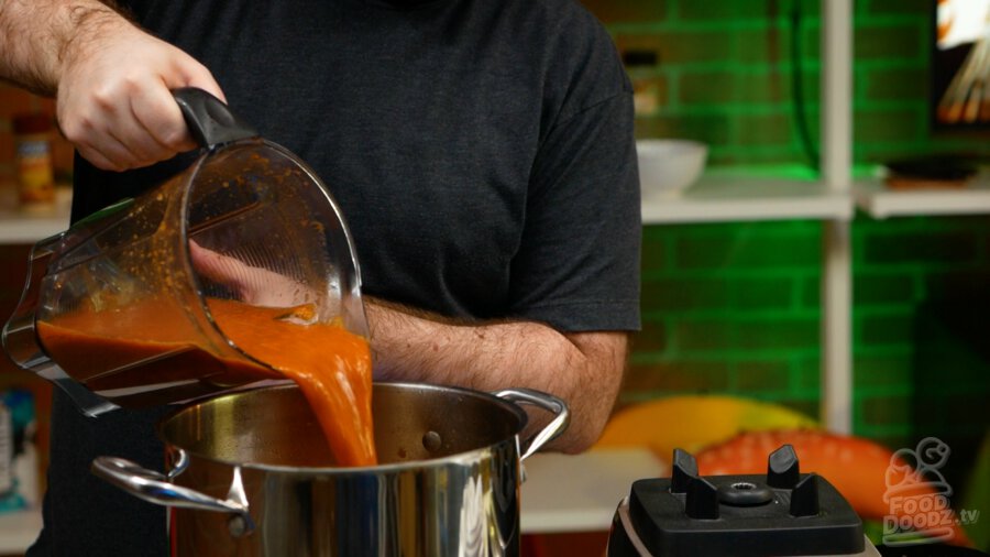 Adding the blended mixture to the pot.