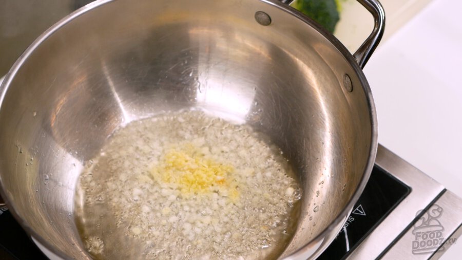 Frying the garlic and ginger in a hot wok