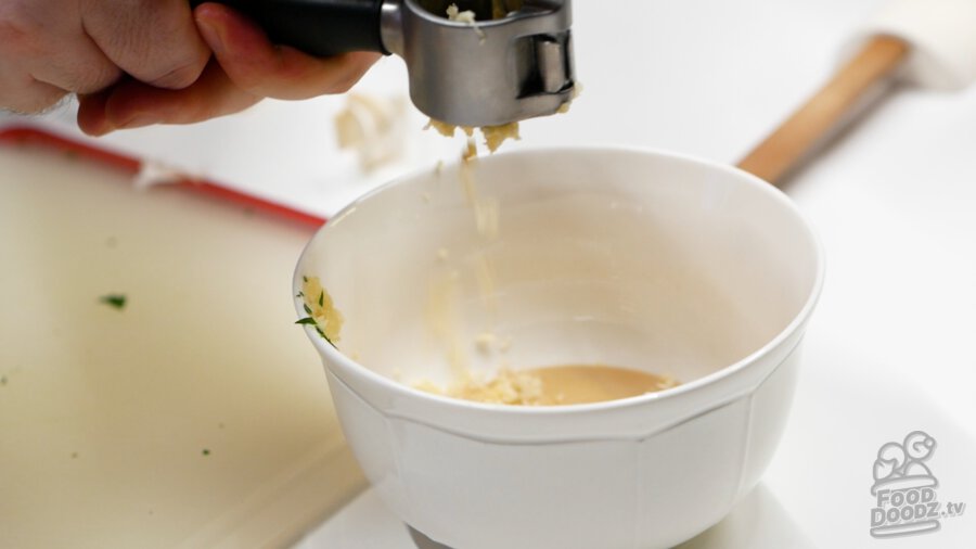 Adding minced garlic to bowl