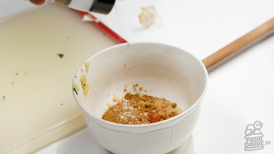 Adding salt, ground cumin, ground cayenne, and ground coriander to bowl.