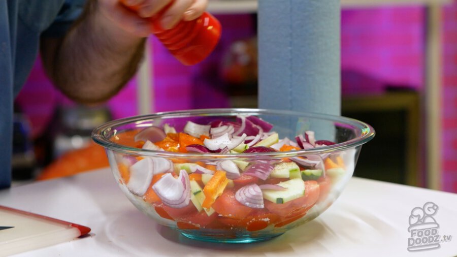 Adding black pepper to chopped veggies