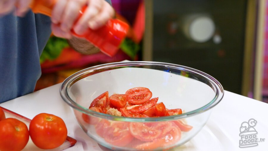 Adding black pepper to tomatoes