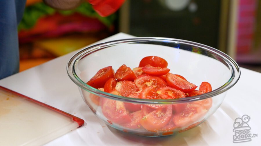 Adding salt and black pepper to new layer of tomatoes