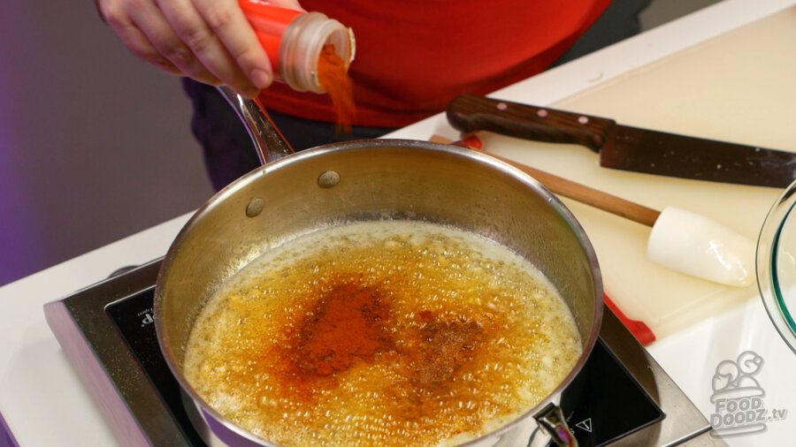 Adding cayenne powder to pan