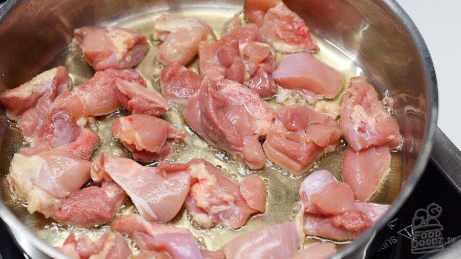 adding seasoned chicken pieces into pan