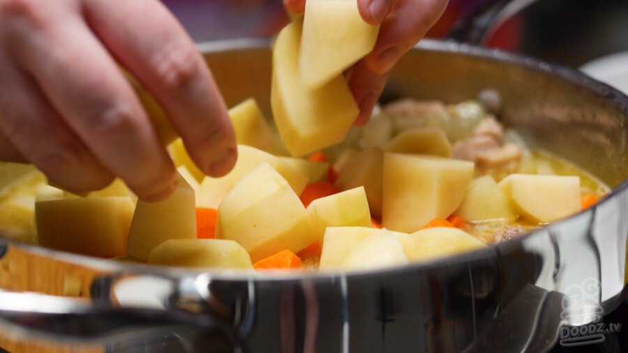 adding carrots and potatoes to pan