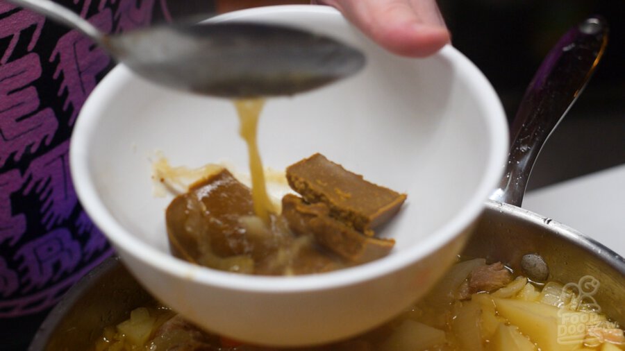 adding some of our cooking liquid to the curry blocks