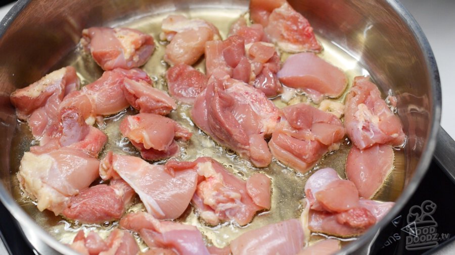 adding seasoned chicken pieces into pan