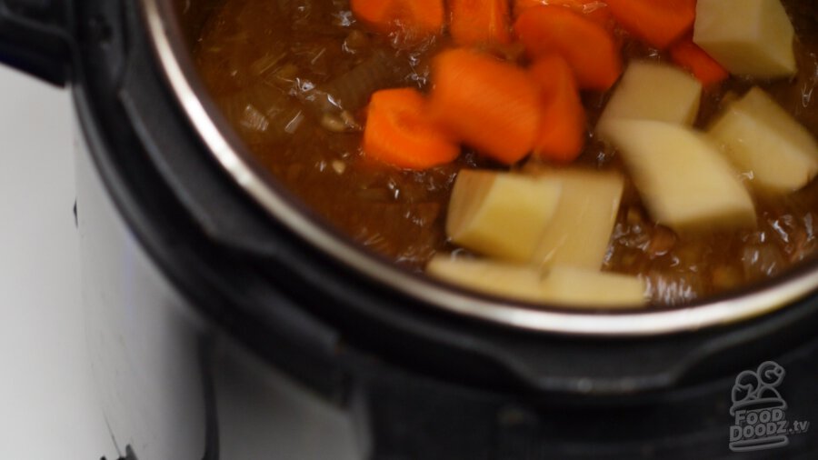 adding potatoes and carrots to pressure cooker